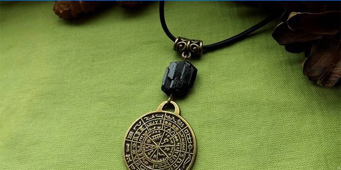 Amuletas su magiškais užrašais ant nėrinių