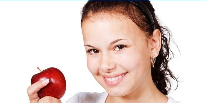 Mergaitė su raudonu obuoliu rankoje