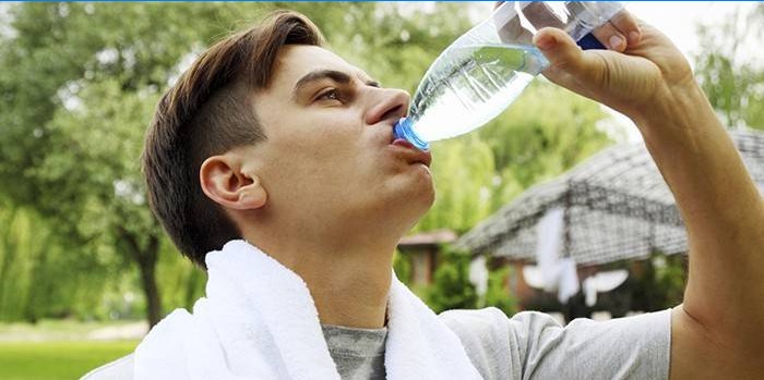 Žmogus geria vandenį iš butelio