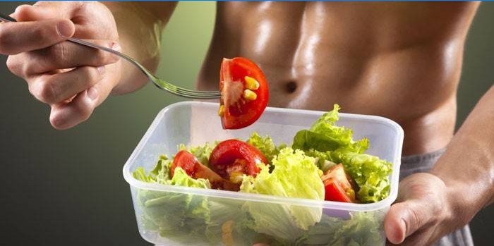 Vyras valgo daržovių salotas su pomidorais
