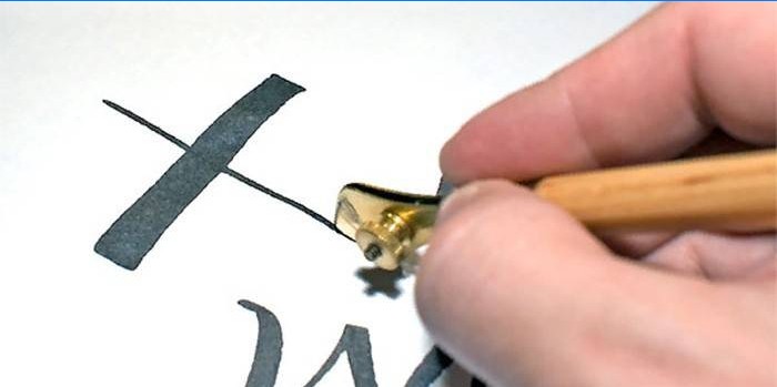 Žmogus piešia hieroglifą piešimo rašikliu