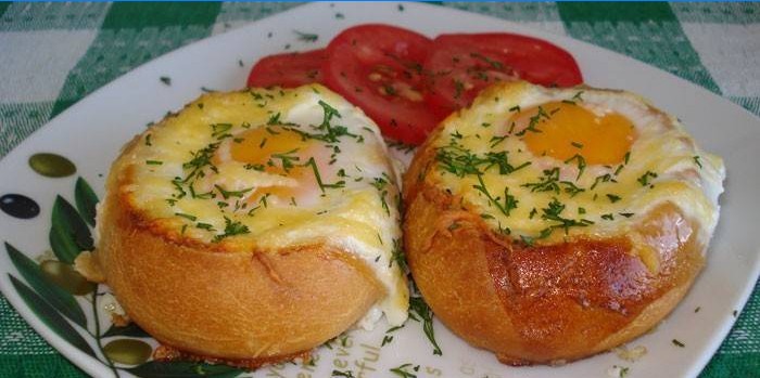 Kepti kiaušiniai bandelėje su sūriu ant lėkštės