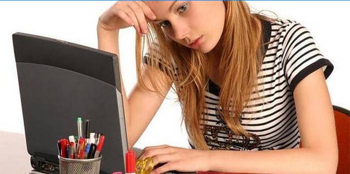 Mergina prie nešiojamojo kompiuterio