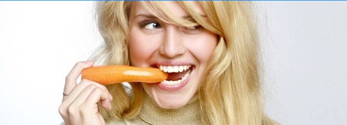 Mergaitė valgo morką