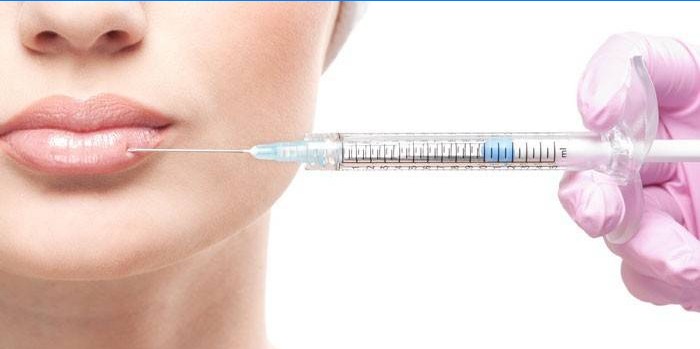 Moteris injekuoja Botox ant lūpų