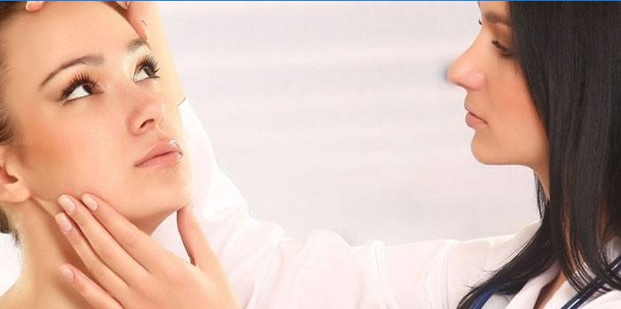Kosmetologė apžiūri moters veidą prieš „Botox“ injekcijas.