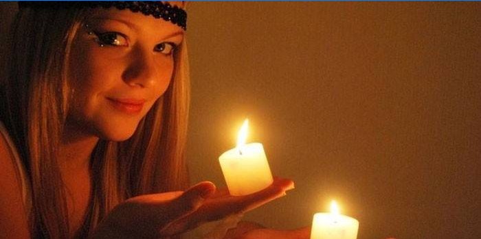 Mergaitė su žvakėmis rankose