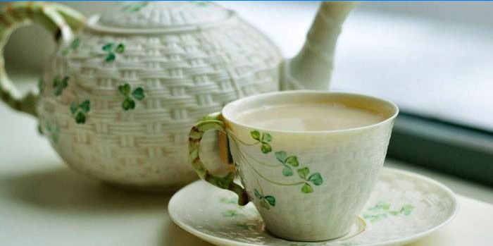 Žalioji arbata su pienu puodelyje ir arbatinukas