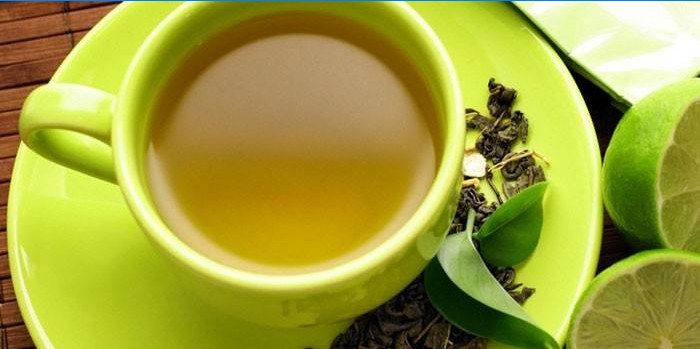 Žalioji arbata puodelyje ir kalkės