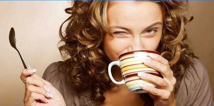 Mergaitė geria arbatą iš puodelio