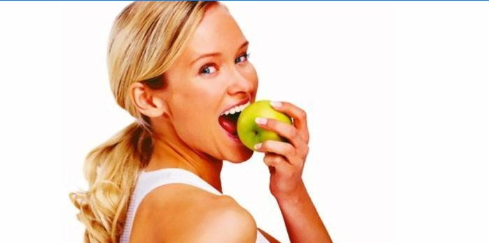 Mergaitė valgo obuolį