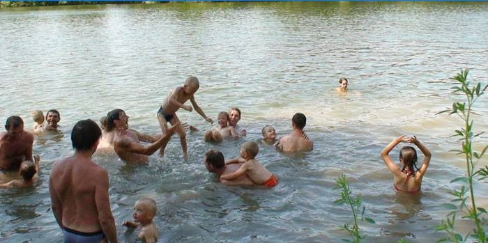 Žmonės maudosi upėje